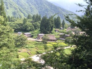 合掌造りの屋根越しに見える山稜と空です。