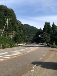 山肌に沿って続く国道と夏の青空です。